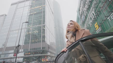 woman getting out of a car in a city