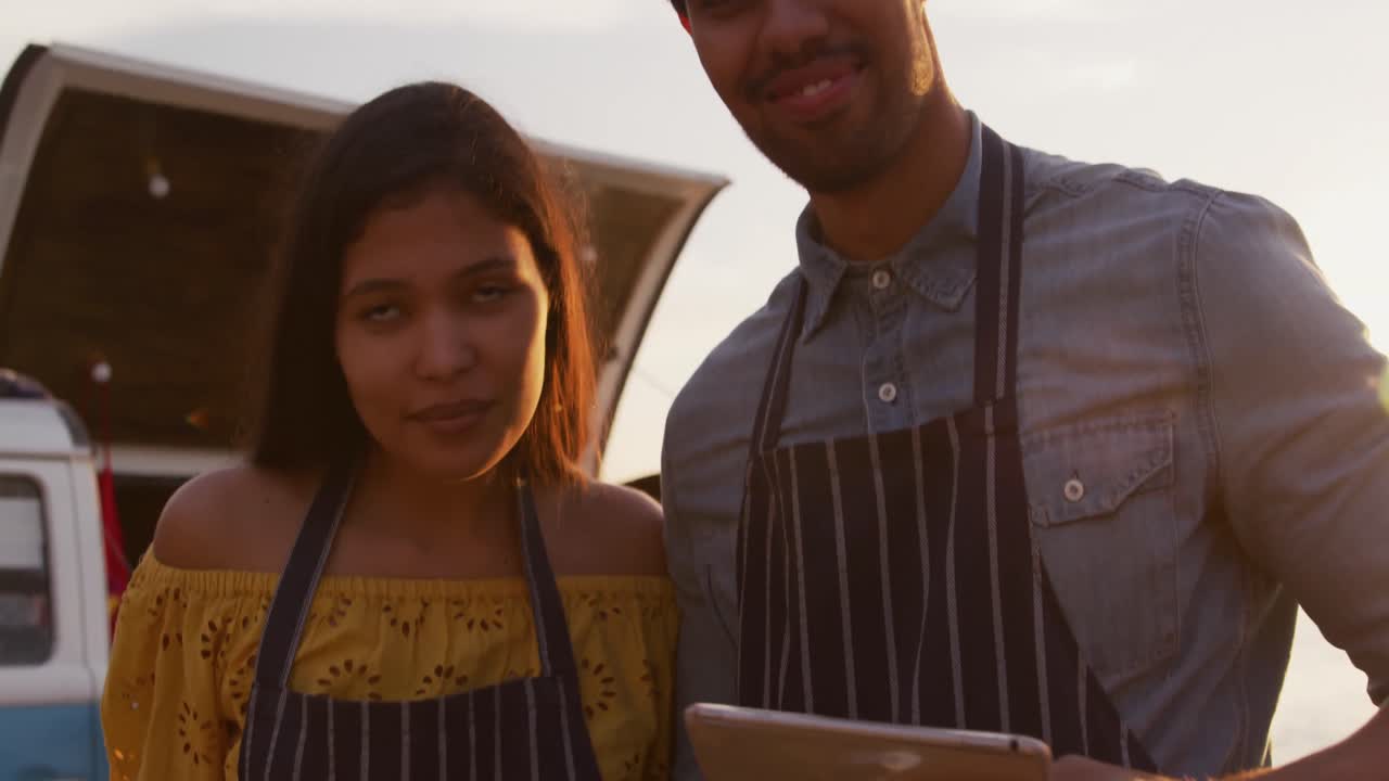 una joven pareja mirando la cámara en un camión de comida