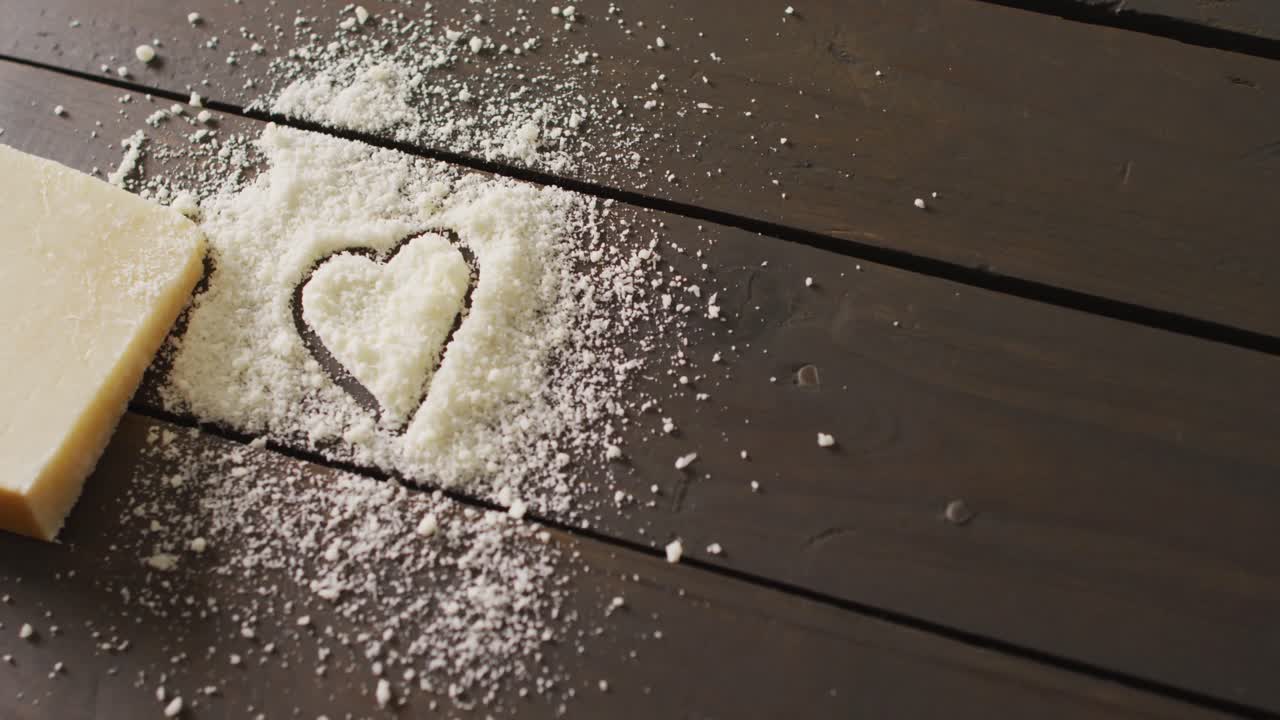 видео блока твердого сыра и сердца, нарисованного в нарезанном сыре на деревенском столе с копировальным пространством