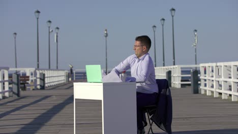 surprised adult handsome businessman waking up on his desk on after taking a nap on a wooden pier