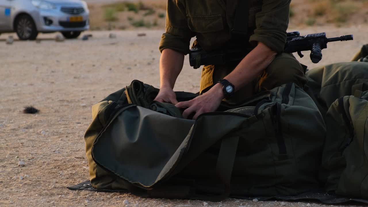 Close-up of soldiers hands prepare his equipment in his military bag ready to war
