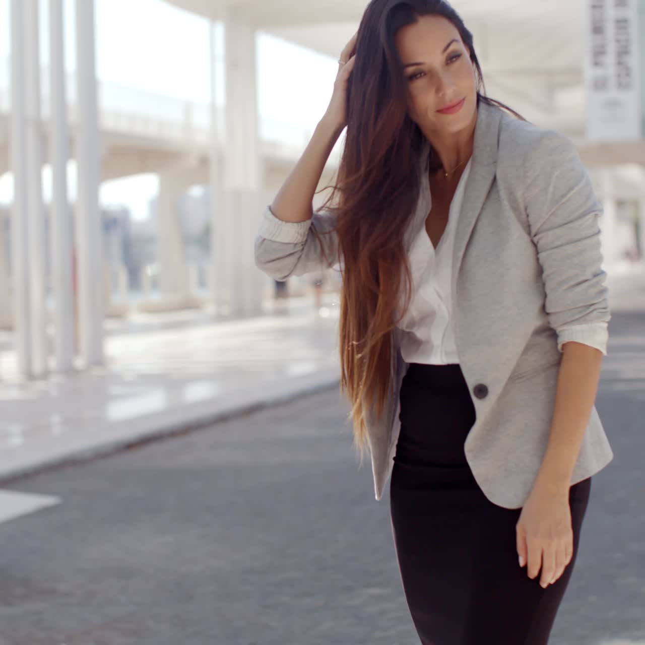 mujer elegante con el pelo largo de pie en un móvil