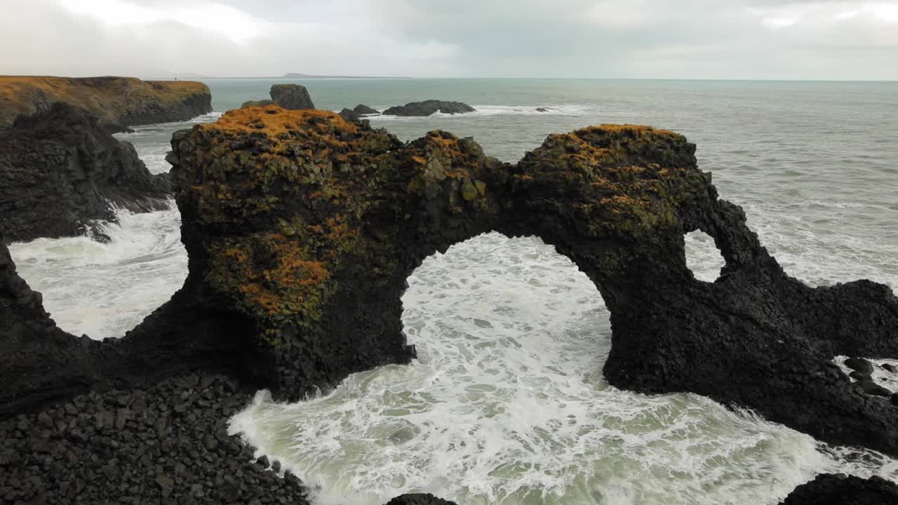 la hermosa formación de arco de roca negra en la playa de diamantes en islandia junto al mar - toma amplia
