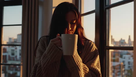 woman enjoying morning coffee by the window
