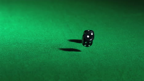 black dice falling on green table