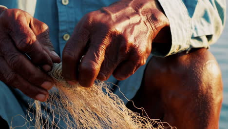elderly fisherman repairing fishing net
