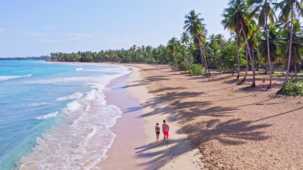 pareja en traje de baño caminando juntos en la playa caribeña tropical