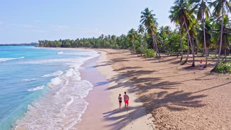 couple in swimwear walking together on tropical caribbean beach