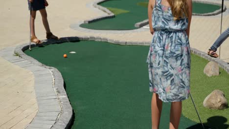 kids playing miniature golf in the garden 4k