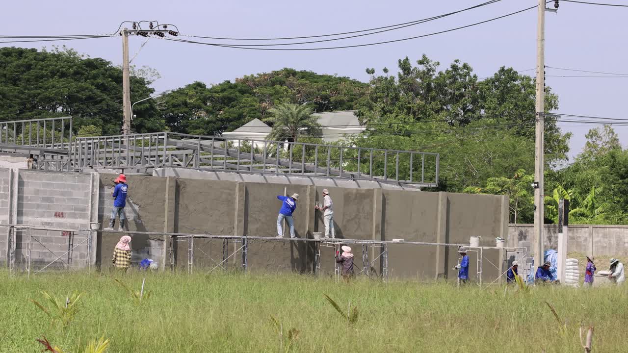 한 무리의 사람들이 함께 벽을 칠하고 있습니다.