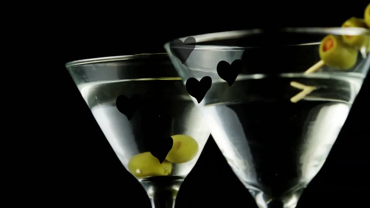 animación de corazones flotando sobre vasos de martini sobre un fondo negro