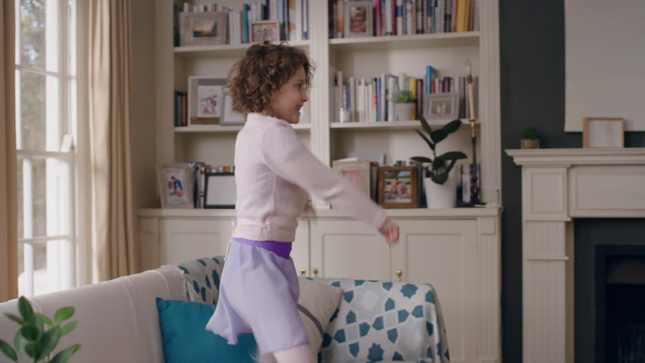 happy little girl dancing at home jumping on sofa having fun playful dance enjoying childhood freedom wearing purple dress 4k