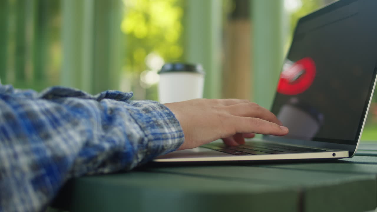 Woman is working with laptop in the green park co-working. Chatting with netbook outdoor close-up.
