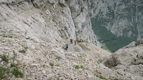 hikers climbing up a mountain on a steep part of a climb