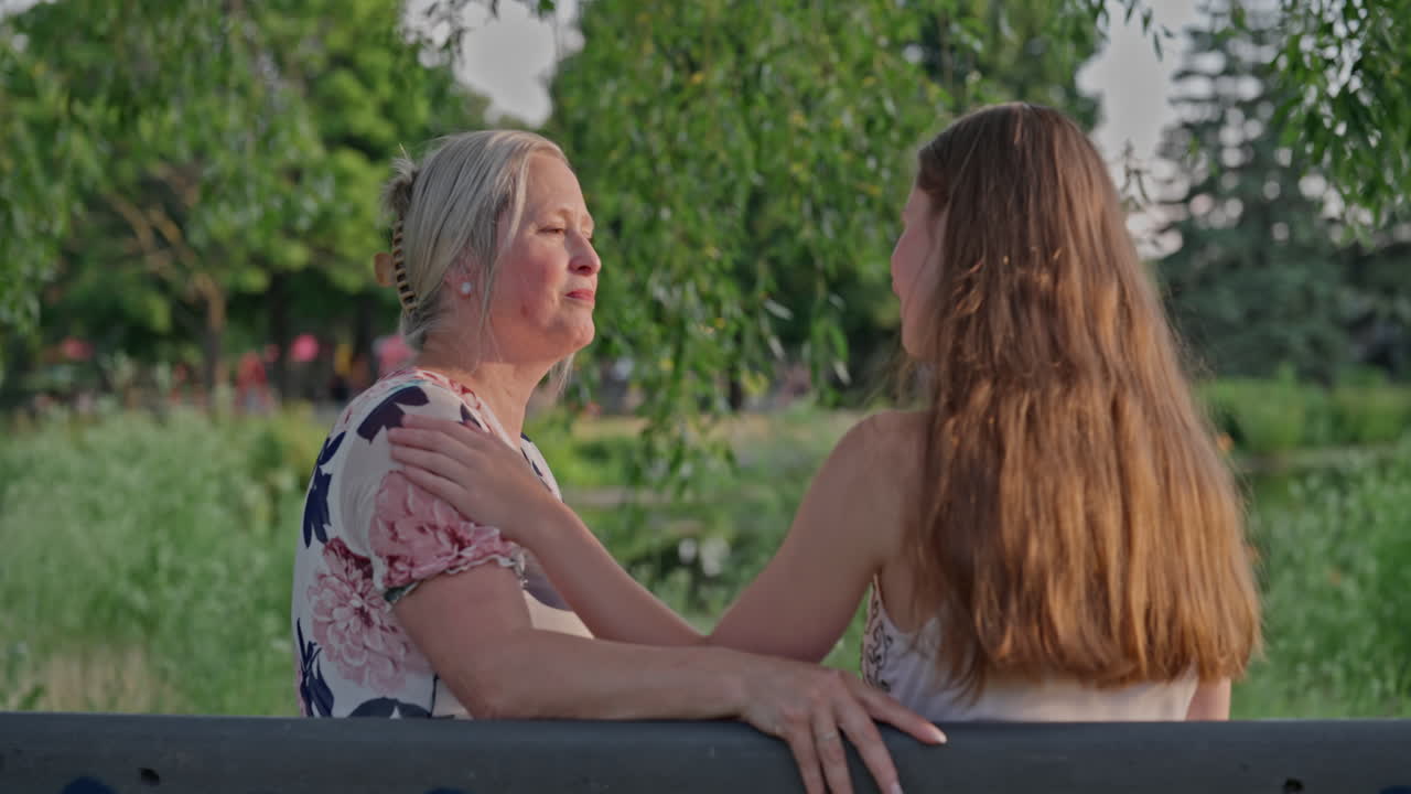 A Young Woman Shares A Tender Moment With Her Mother On A Park Bench, Ending In A Heartfelt Hug. Shot In Natural Light, Full Of Love, Trust, And Emotional Warmth