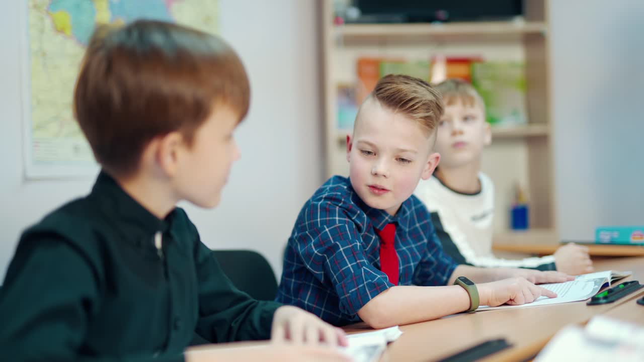 Back to school. Little boys studying at school. Group of smiling kids sitting at the table and talking. Education concept.