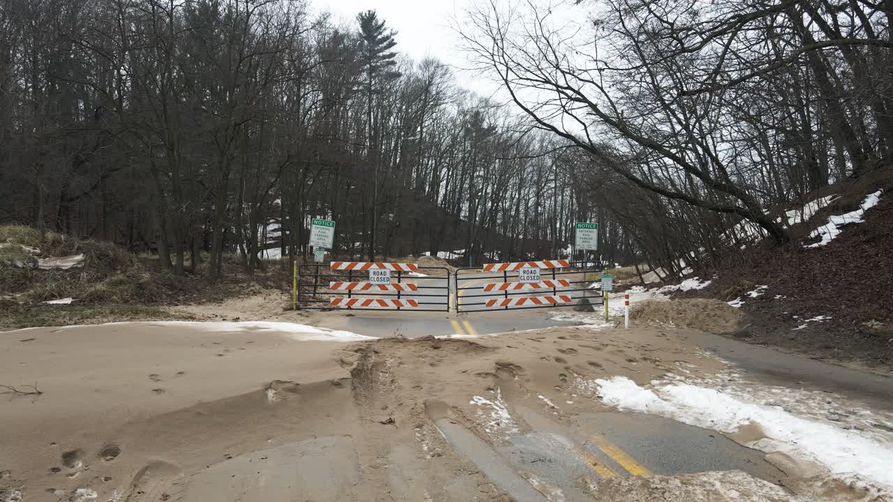 해변가에 폐쇄된 도로 표지판을 보여주기 위해 드론으로 천천히 밀고 있습니다.