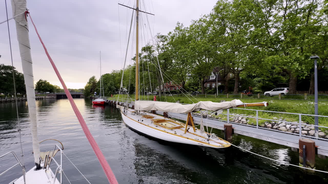 Tranquil Evening on the Kiel Canal Classic Sailboats Find Refuge Along the Historic Waterway, their Reflections Dancing in the Calm Waters as Dusk Approaches