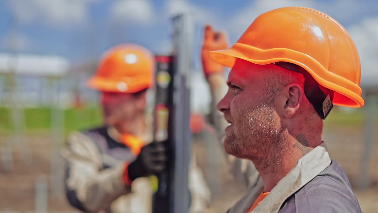 Engineers installing solar panels frame. Portrait of construction workers on site