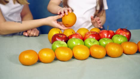 little girl with fruits on table. close up view of girl with fruits on table