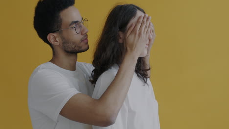 couple posing against yellow background