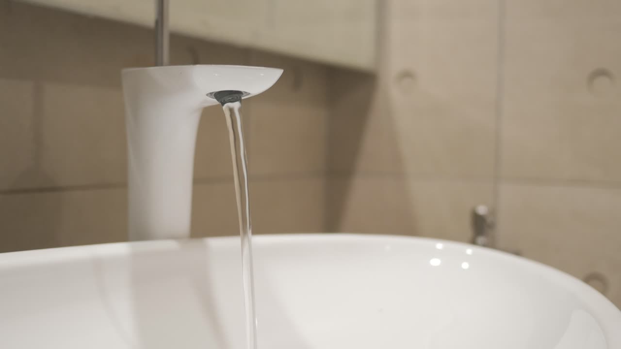 Agua que sale de un grifo a cámara lenta