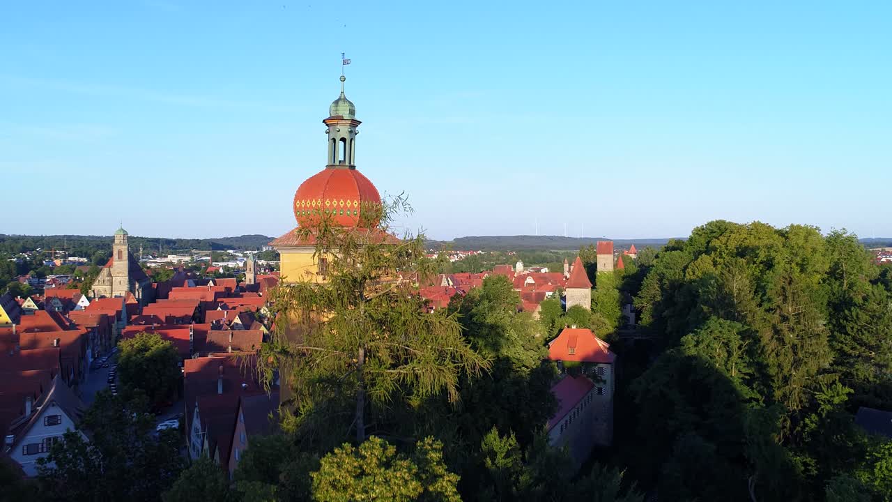 un drone è salito lentamente oltre un albero, poi oltre la torre sulle mura della città bel panorama durante il giorno della città vecchia prima del tramonto