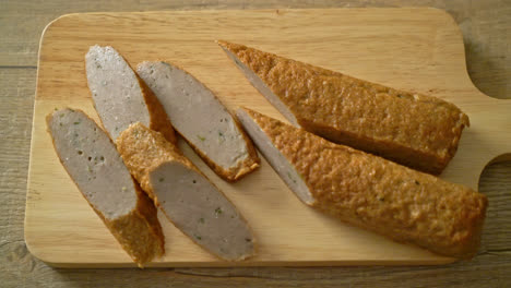 pastel de pescado chino frito o línea de bolas de pescado en tablero de madera