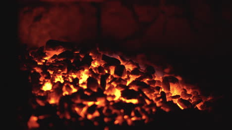 fiery coals in dark stove, nighttime heat source close-up