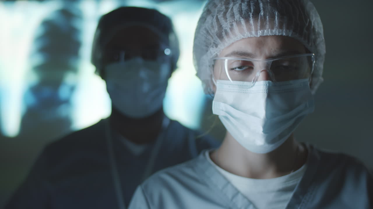 Ritratto di operatori sanitari in uniforme protettiva in un laboratorio buio