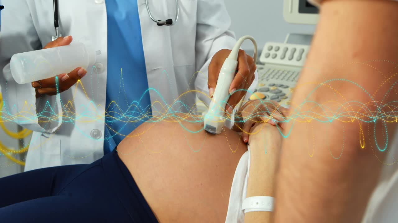Clinico che applica gel e scansiona la pancia di una donna incinta in clinica, con dati fetali animati che appaiono sulla console.