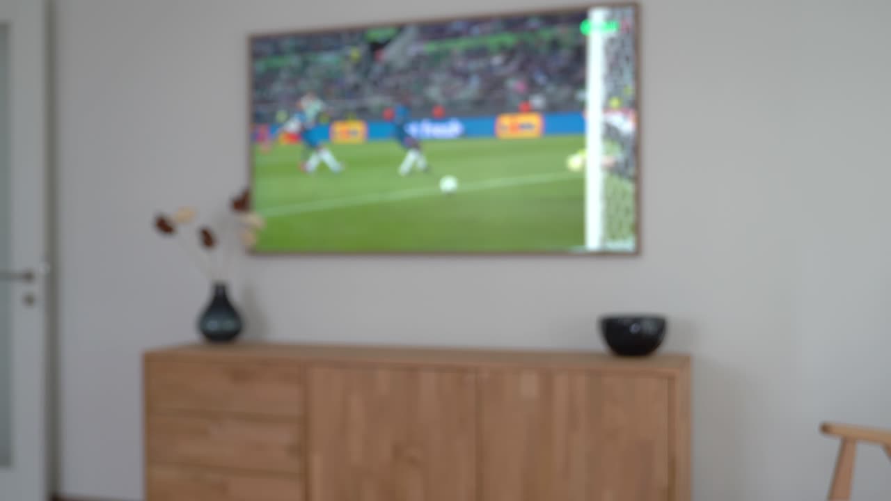Uomo con una smart TV che usa un telecomando