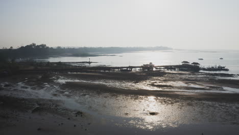 Sea-harbor-jetty-and-beach-at-low-tide-in-hazy-sunlight,-Thailand