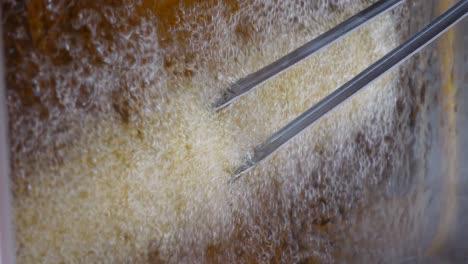 freír alimentos en un baño de aceite caliente