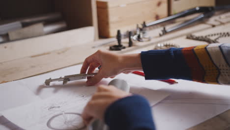 Close-Up-Of-Female-Engineer-In-Workshop-Measuring-Components-For-Bicycle-With-Micrometer