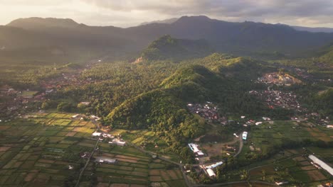 Cinematic-sunset-view-of-mountain-range,-tropical-forests,-rice-fields-and-small-Balinese-villages-in-Karangasem,-East-Bai,-Indonesia