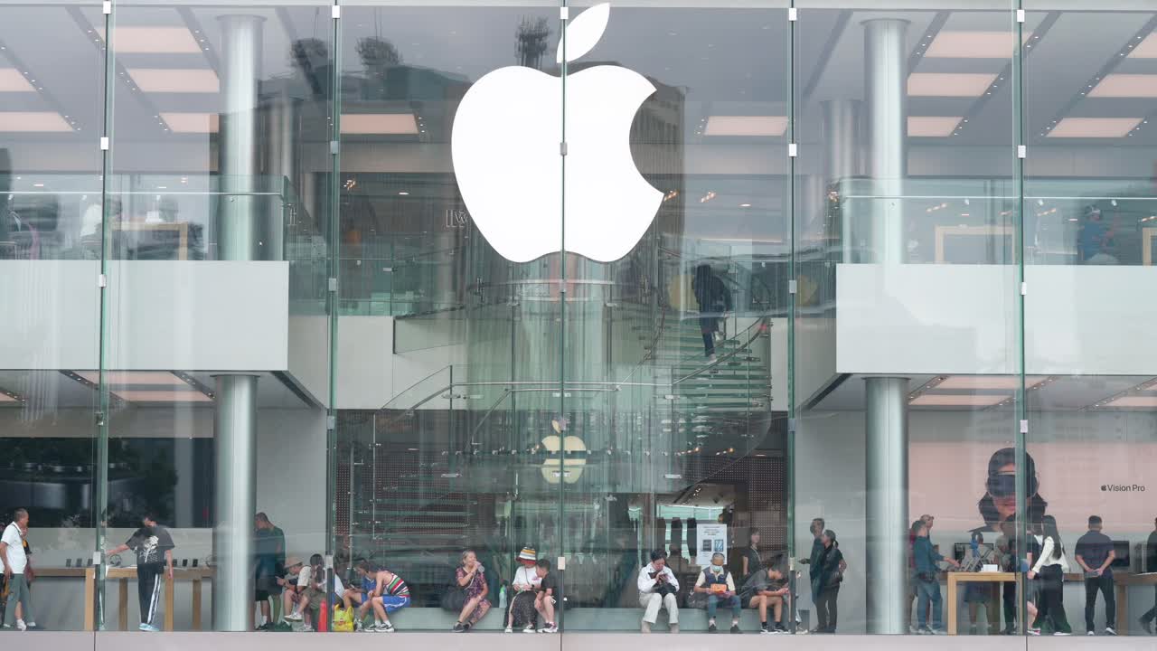 A wide shot captures customers shopping at the Apple Store, the American technology company, in Hong Kong.