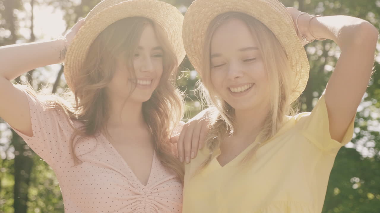 두 명의 행복한 여성들이 공원에서 포즈를 취하고 있습니다.