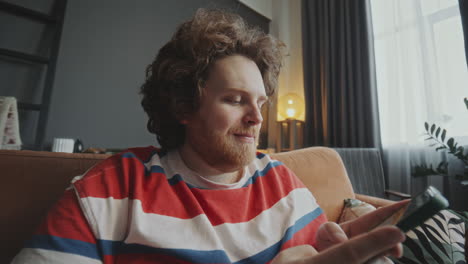 man using phone on a couch