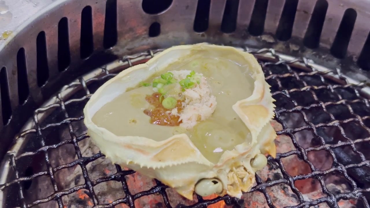 日本料理における高級海鮮珍味として美しく盛り付けられた、濃厚でクリーミーなカニ味噌が詰まったカニの甲羅のクローズアップ