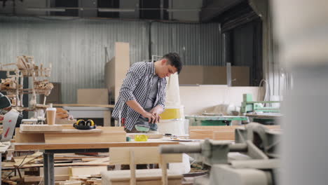 woodworker sanding wood in workshop
