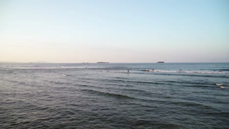 distant view of surfers riding waves