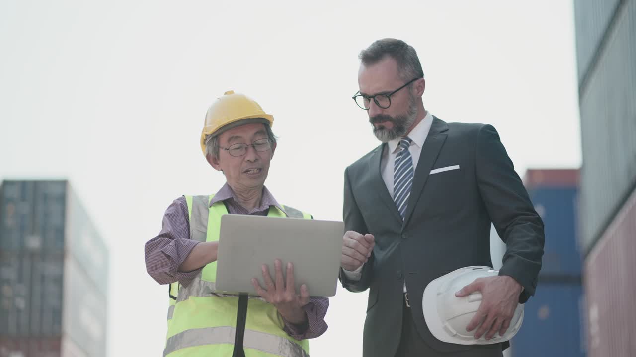 ingeniero senior y gerente o inversor o negocio de propiedad, detalle de la charla del proyecto o proceso de carga de carga y proceso de envío en portátil en el patio de carga de contenedores. personas multirraciales, cooperación en negocios.