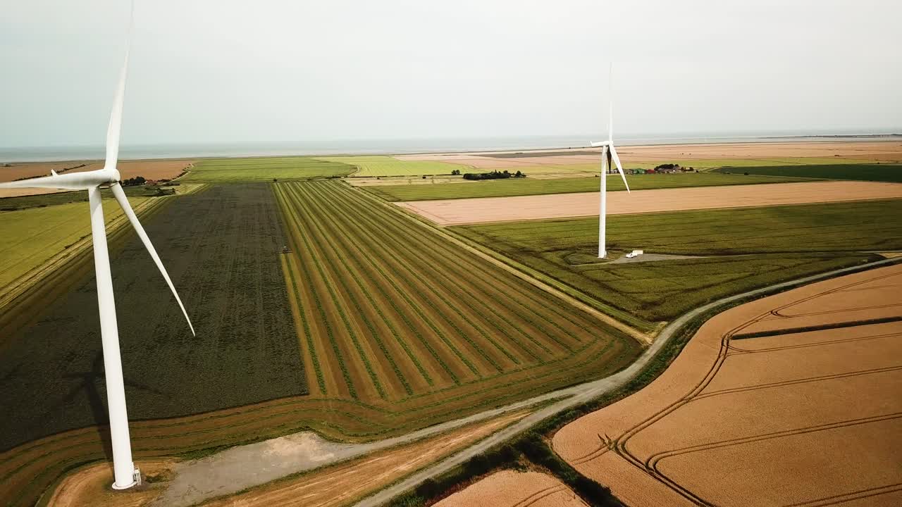 Wind turbines spin over agriculture fields