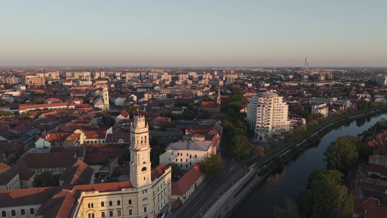 Pohled z dronu na historické evropské město s řekou protékající městskou krajinou během zlaté hodinky.