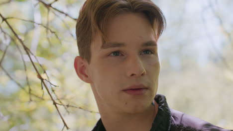 warrior stands quietly in forest, making silent observation by shifting eyes left and right without turning head, focused and cautious as sunlight filters through trees highlighting tattoo on neck