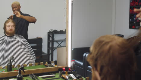 hombre cortándose el cabello en la barbería