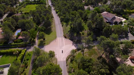 Aerial-tracking-shot-of-a-motor-bike-rider-driving-along-a-street-in-Montpellier