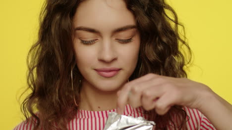 young woman opening chocolate bar