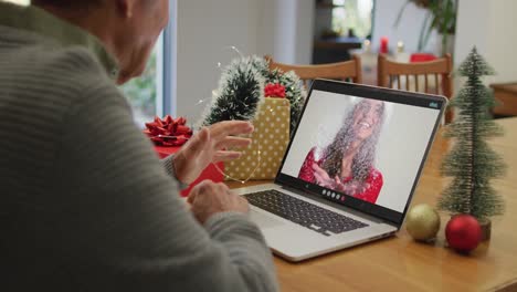 hombre caucásico mayor en videollamada con su hija adulta en tiempo de navidad
